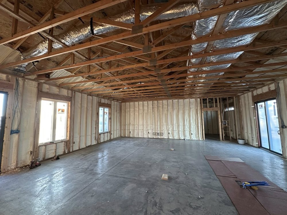 A BlackRidge interior mid-build: clean framing, spray foam, daylight pouring in